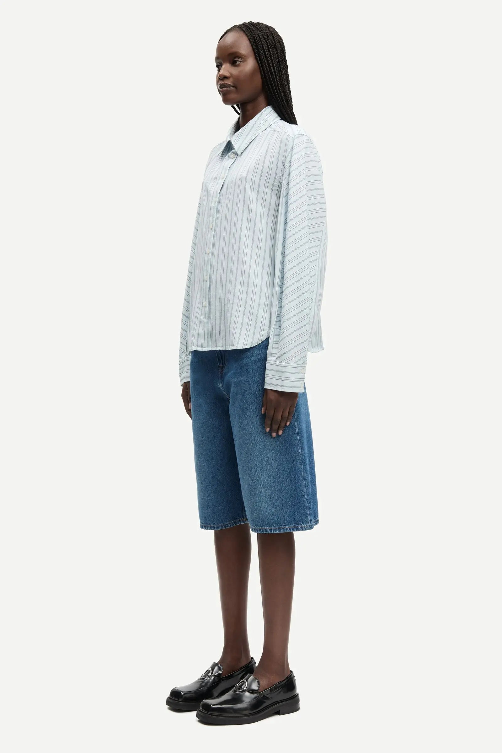 Woman wearing a light blue striped shirt and blue jeans on a white background jorts west Vancouver paloma sale samsoe samsoe